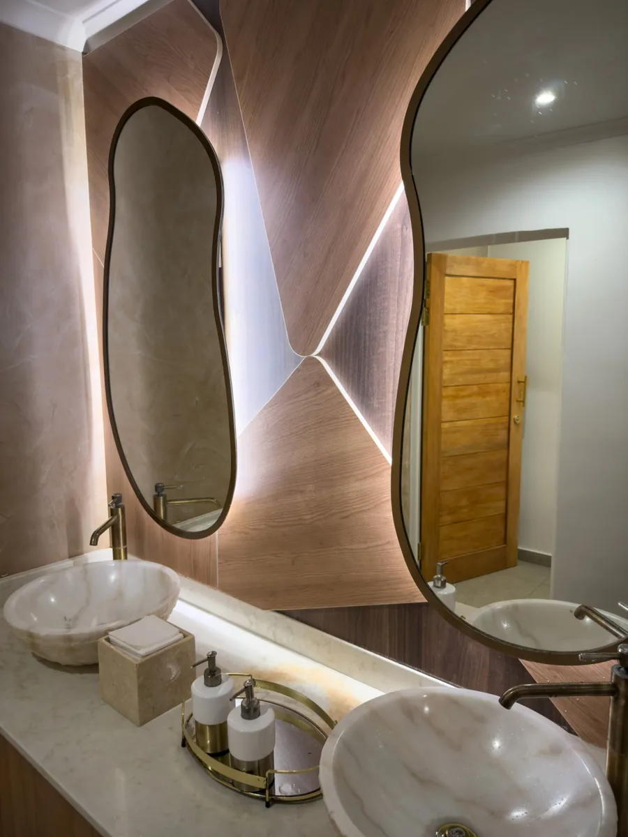 Backlit LED mirror lighting glowing above his-and-hers vanity basins