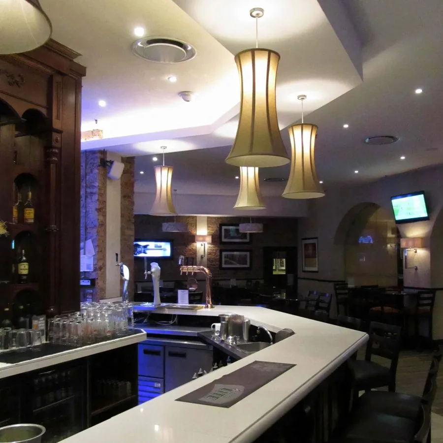 Flared gold pendant shades above a restaurant bar counter